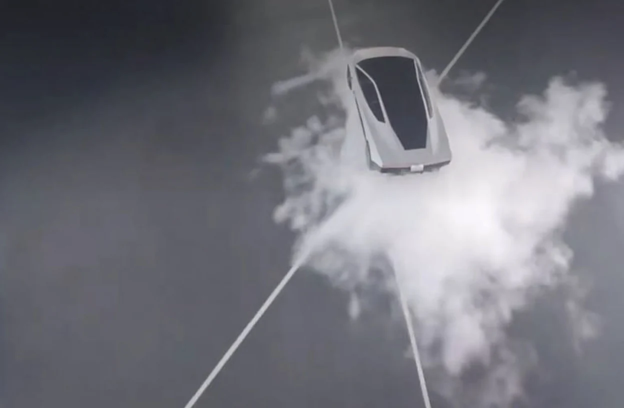 Overhead view of a silver Tesla Roadster above the test pad, rising out of a burst of white thruster vapor